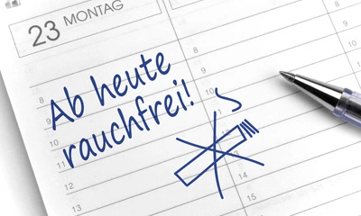 Nahaufnahme einer handschriftlichen Notiz in einem Terminplaner mit der Botschaft „Ab heute rauchfrei!“ und einem durchgestrichenen Zigaretten-Symbol.